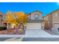 Two story house with beige exterior, attached garage, and landscaping at 6512 Copper Smith Ct, North Las Vegas, NV 89084