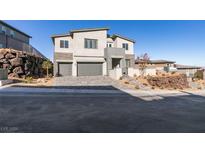 Two-story modern home with gray exterior, three-car garage, and landscaped yard at 522 Riley Ridge Ct, Henderson, NV 89012