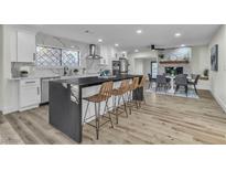 Modern kitchen with island, stainless steel appliances, and breakfast bar at 5858 El Parque Ave, Las Vegas, NV 89146