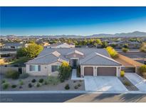Single-story house with a two-car garage, landscaped yard, and mountain views at 8243 Twin Rock Ct, Las Vegas, NV 89113