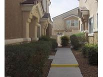 Pathway between two-story townhouses with landscaping at 9133 Forest Willow Ave # 102, Las Vegas, NV 89149