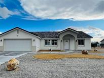 Newly constructed single-story home with a two-car garage and landscaped front yard at 681 Indian Wells Ct, Pahrump, NV 89060