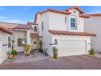 Two-story Spanish style home with tile roof, two-car garage, and landscaped front yard at 8715 Villa Ariel Ln, Las Vegas, NV 89147