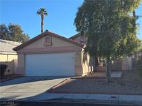 Single-story house with a white garage door and landscaped front yard at 8976 Quarrystone Way, Las Vegas, NV 89123