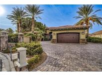 Spanish style home with a 3-car garage, mature landscaping, and a paved driveway at 2 Via Siena Pl, Henderson, NV 89011