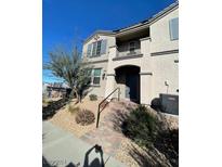 Two-story townhome with gray siding, shutters, and a small front yard at 447 Filaree Pl, Henderson, NV 89015