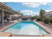 Inviting backyard oasis featuring a sparkling pool, covered patio, and hot tub at 4761 Lake Pl, Las Vegas, NV 89147