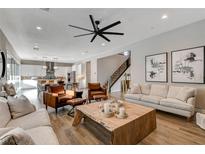 Open living area with hardwood floors, leather armchairs, and a large, wood coffee table at 8967 Rolling Pietra St, Las Vegas, NV 89166