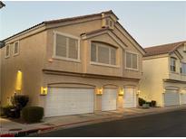 Tan two-story house with a two-car garage and landscaping at 1628 Clint Canyon Dr, Henderson, NV 89002