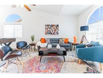 Bright living room with gray sofa, colorful rug, and foosball table at 175 Enloe St, Henderson, NV 89074