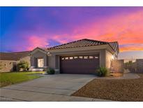 Single-story home with attached garage, landscaping, and a sunset in the background at 2540 Youngdale Dr, Las Vegas, NV 89134