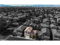 Aerial view of a house in a residential neighborhood with city skyline in the background at 886 Park Walk Ave, Las Vegas, NV 89123