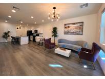 Open living area features hardwood floors, stylish furniture, and a chandelier at 712 Cottonwood Hill Pl, Henderson, NV 89011