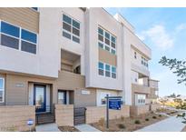 Modern 2-story townhome with light brown and white exterior, and blue door at 2486 Indigo Mountain St, Henderson, NV 89044