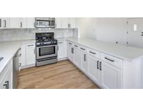 Modern white kitchen with stainless steel appliances and quartz countertops at 2504 Clayton St, North Las Vegas, NV 89032