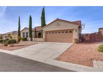 Tan, single-story home with a driveway, attached garage, and desert landscaping at 2129 Colvin Run Dr, Henderson, NV 89052