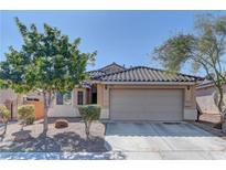 Single-story house with a two-car garage and well-maintained landscaping at 5899 Lewis Falls Ave, Las Vegas, NV 89139