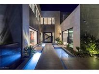 Modern home exterior at night with water feature and pathway at 32 Highland Cove Ln, Henderson, NV 89011