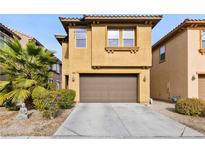 Tan two-story house with brown garage door and landscaping at 324 Trailing Putt Way, Las Vegas, NV 89148