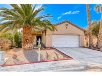 Single-story house with a white garage door and desert landscaping at 227 Gray Granite Ave, Las Vegas, NV 89123