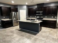 Modern kitchen with dark cabinets, granite counters, and stainless steel appliances at 7232 Halo Falls St, North Las Vegas, NV 89084