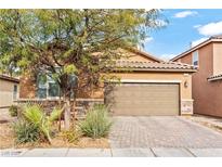 Inviting single-story home with a paved driveway, attached two-car garage, and desert landscaping at 778 Star Apple Ln, Las Vegas, NV 89178