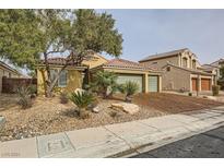 Single-story house with three-car garage, desert landscaping, and brick driveway at 3732 Via Di Girolamo Ave, Henderson, NV 89052