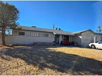 Single-story home with attached garage and gravel landscaping under a clear blue sky at 6545 Casada Way, Las Vegas, NV 89107