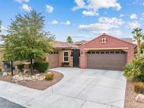 Inviting single-story home with a three-car garage and landscaped front yard at 7141 Royal Melbourne Dr, Las Vegas, NV 89131
