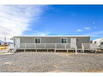 Gray manufactured home with a deck at 4901 Maple Rd, Pahrump, NV 89048