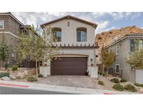 Inviting two-story home with attached garage, landscaped yard, and desert landscaping at , Henderson, NV 89011