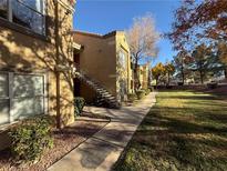 Apartment building exterior with walkway, landscaping, and trees at 2300 E Silverado Ranch Blvd # 1196, Las Vegas, NV 89183