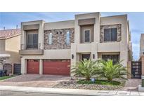 Modern two-story home with a red garage door, stone accents, and desert landscaping at 5989 Rockway Glen Ave, Las Vegas, NV 89141