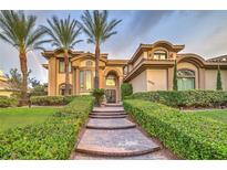 Elegant two-story home with palm trees, lush landscaping, and a paved walkway leading to the entrance at 8905 Greensboro Ln, Las Vegas, NV 89134