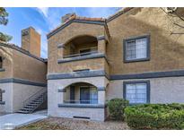 Two-story condo with balcony, stairs, and landscaping at 220 Mission Newport Ln # 106, Las Vegas, NV 89107
