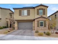 Two-story home with a stone and stucco exterior, attached two-car garage, and landscaped front yard at 10116 Skye Castle Dr, Las Vegas, NV 89166