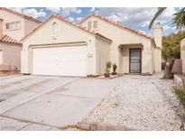 Front exterior of a single-story home with a two-car garage, landscaped yard, and decorative rock accents at 2106 Big Boulder Dr, North Las Vegas, NV 89031