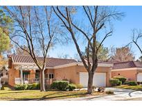 Single-story home with a terracotta tile roof, white garage door, and landscaped yard at 2820 Linkview Dr, Las Vegas, NV 89134