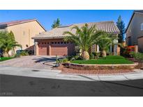Two-story house with a two-car garage, landscaping, and palm trees at 10042 Pipestone St, Las Vegas, NV 89141