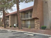 View of two-story apartment building exterior with balconies, trees, and parking at 5152 River Glen Dr # 465, Las Vegas, NV 89103