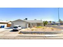 Ranch-style home with attached garage and landscaped yard at 400 E Rolly St, Henderson, NV 89011