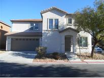 Two-story home with a two-car garage, front yard landscaping, and a paved driveway at 5304 Carlsbad Heights St, North Las Vegas, NV 89081