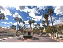 Gated community entrance with palm trees and guardhouse at 2637 Golden Sands Dr, Las Vegas, NV 89128