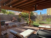 Relaxing backyard oasis with covered patio, artificial turf, and fire pit at 853 Teal Ave, Las Vegas, NV 89123