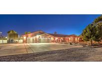 Spacious house with a large three-car garage and well-lit driveway at 8635 W Cougar Ave, Las Vegas, NV 89148