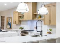 Modern kitchen featuring white quartz countertops and light wood cabinetry at 1928 Oliver Springs St, Henderson, NV 89052