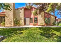 Tan and red two-story home with a well-manicured lawn at 2360 Pickwick Dr, Henderson, NV 89014