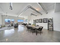 Open living area with city views, concrete floors, and modern furnishings at 900 Las Vegas Blvd # 1211, Las Vegas, NV 89101