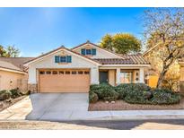 One-story house with tan colored garage door and green shutters at 2423 Tottingham Rd, Henderson, NV 89074