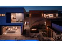 Luxury modern home with wood and stone accents, showcasing a stunning nighttime view at 6860 Milos Rd, Las Vegas, NV 89118